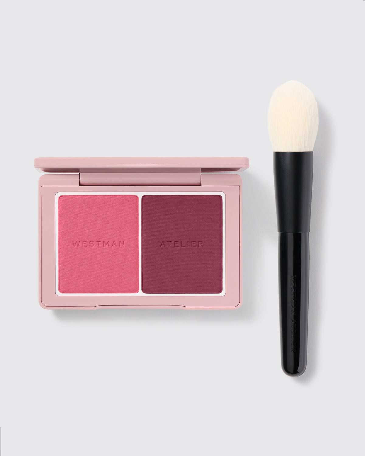 Baby Cheeks Powder Blush Duo palette pictured next to the Powder II Brush on a grey background.