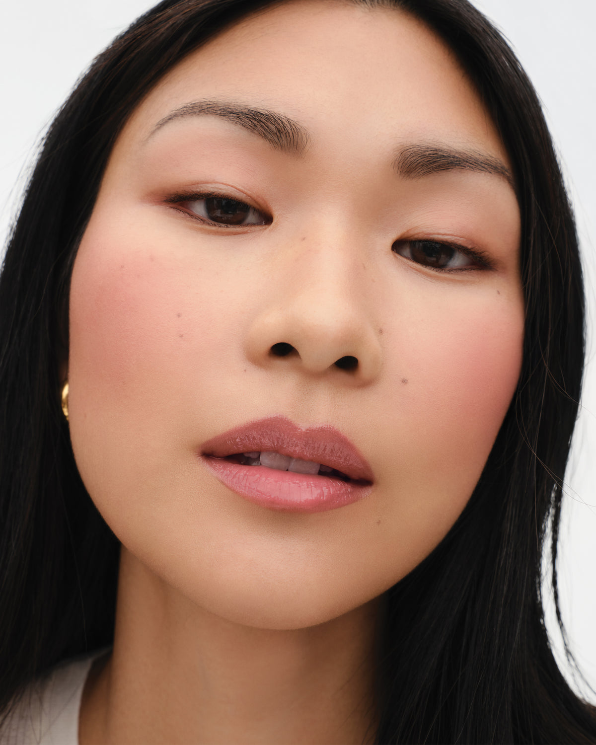 Model wears the Baby Cheeks Powder Blush Duo in Suede / Sable.