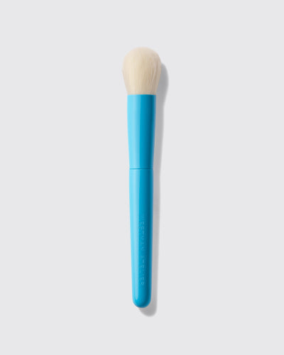 Blue makeup brush with beige bristle head on a light gray background