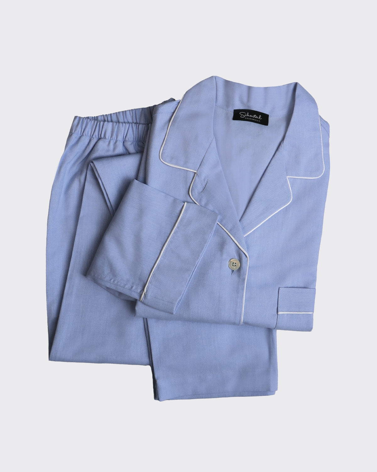 Light blue pajama set with white piping on a light gray background