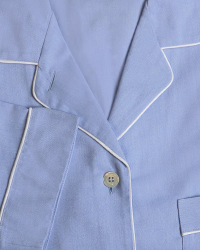 Close-up of a light blue pajama set with white piping