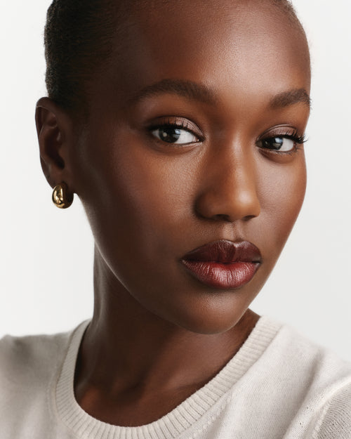 Close-up of a woman wearing red lipstick against a white background