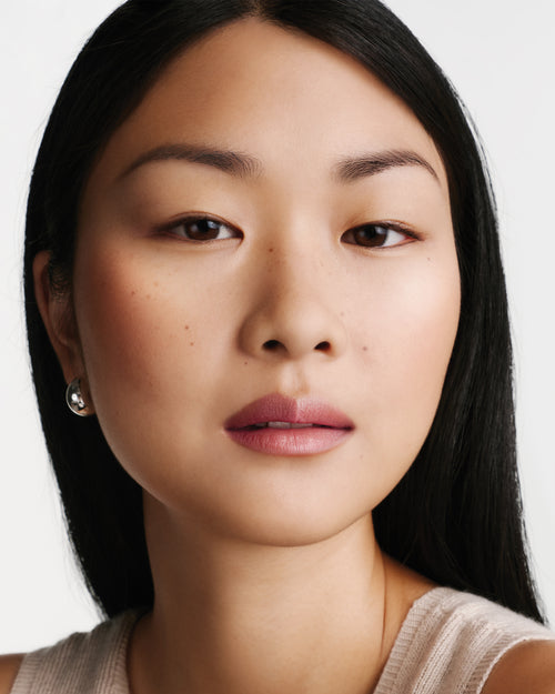 Model wearing HydroBalm in English Rose.
