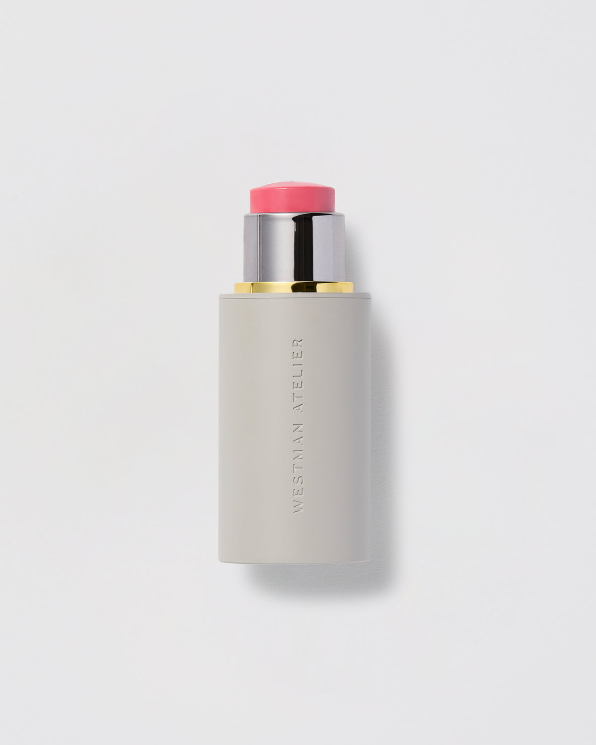Cosmetic stick with pink cap on a light gray background.