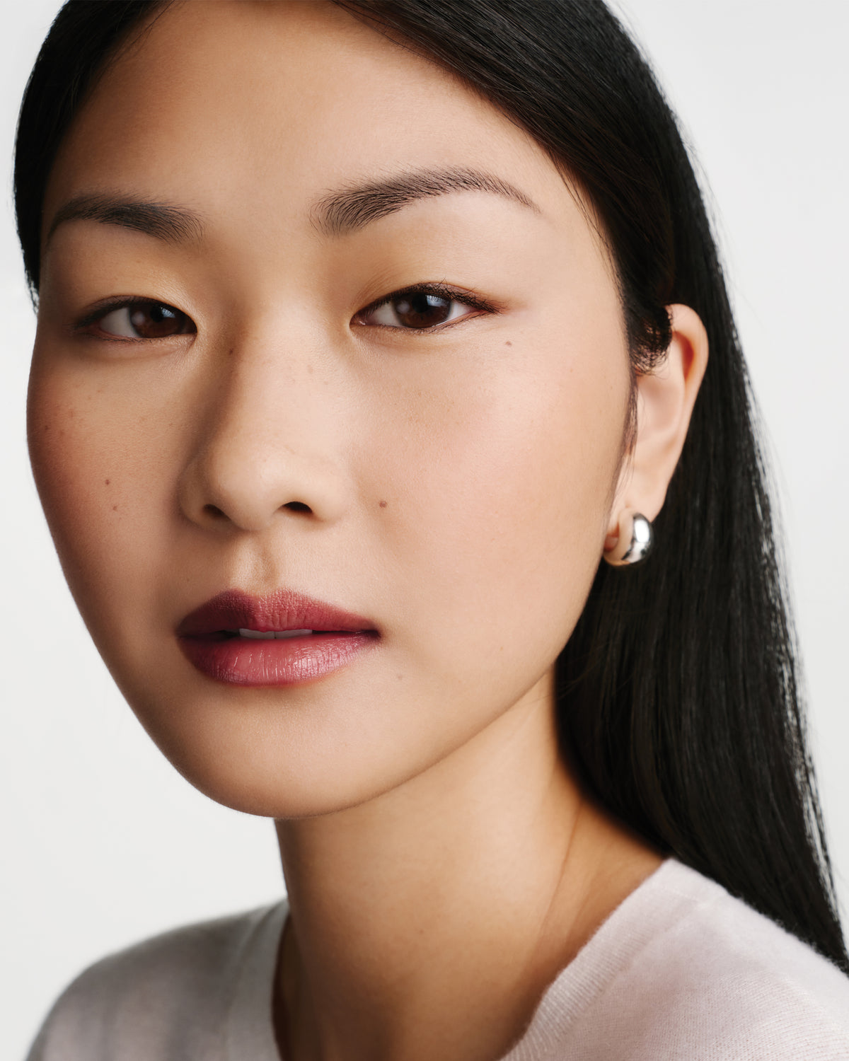 Close up of a model wearing berry lipstick.