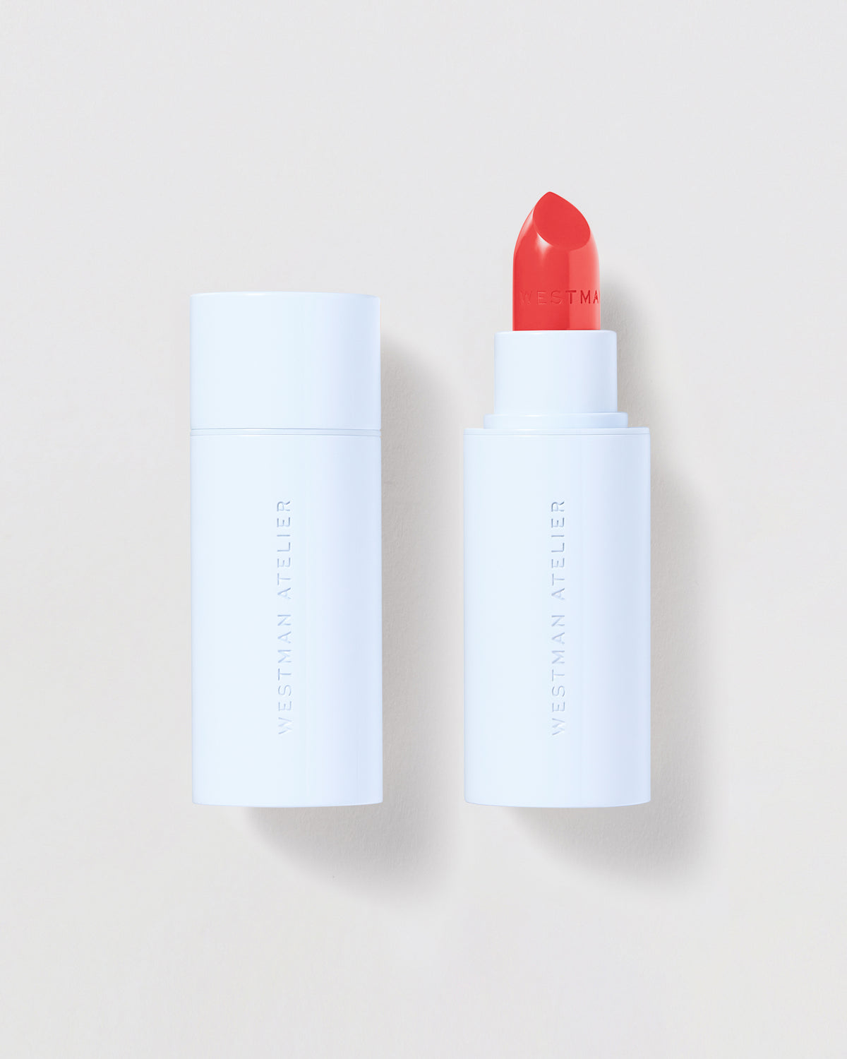 Lipstick with white casing and red cap on a light beige background