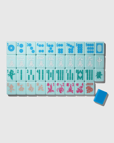 A set of light blue mahjong tiles arranged in a grid on a light gray background, with one blue tile placed separately in the lower right corner.