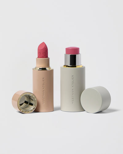 Two lipsticks with their cases on a light gray background