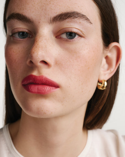 Close-up of a woman's face wearing a red lipstick.