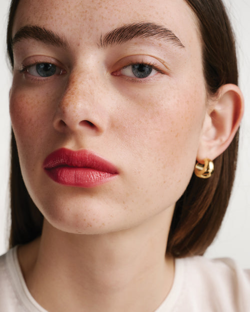 Close-up of a woman's face wearing a red lipstick.