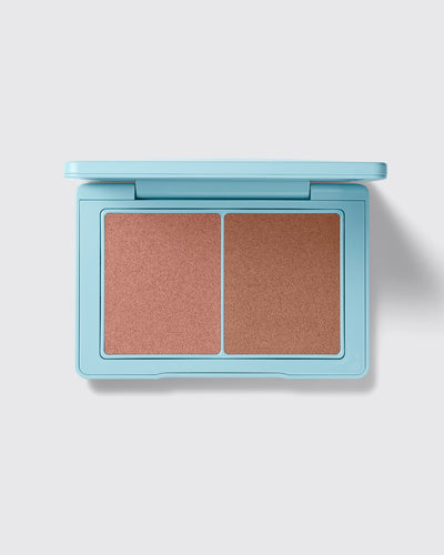 Makeup compact with two brown shades on a light gray background