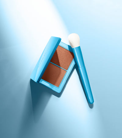 Makeup product with a brush on a light blue background