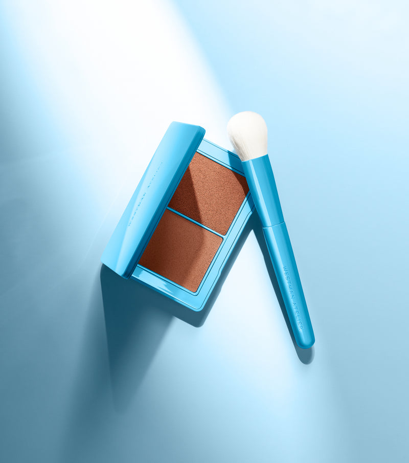 Makeup product with a brush on a light blue background