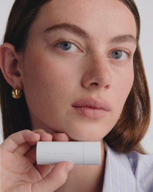 Model applies red lipstick.