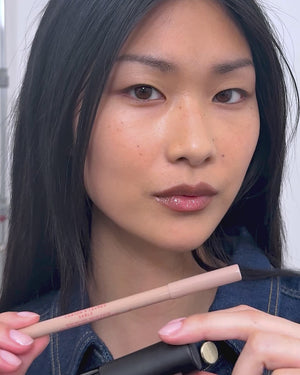 Model applies lip liner in Sable.